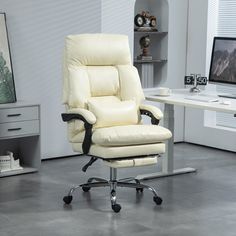 a white leather office chair sitting in front of a desk with a computer on it