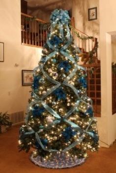 a decorated christmas tree with blue and silver ribbons