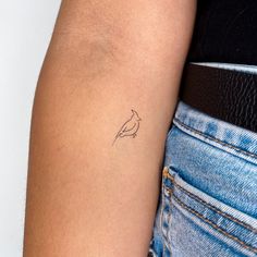 a woman's arm with a small bird tattoo on the left side of her arm