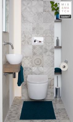 a white toilet sitting next to a sink in a bathroom