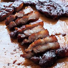 sliced up meat sitting on top of a wooden cutting board