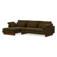 a brown sectional couch with pillows on it's back and armrests, in front of a white background