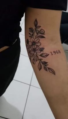 a woman's leg with a flower tattoo on her left arm and the number 661 written in black ink