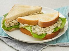 there is a sandwich with lettuce and chicken salad on the plate next to it