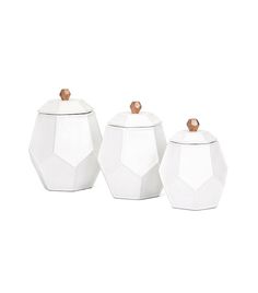 three white ceramic jars with wooden lids