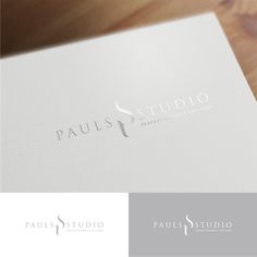 the logo for pauls studio is shown on a wooden table with a pen and paper