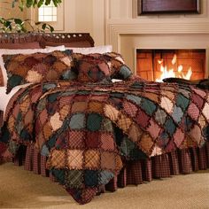 a bed in a room with a fire place next to it and pillows on the bedspread