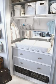 an open closet with white drawers and lots of items on the shelves in front of it