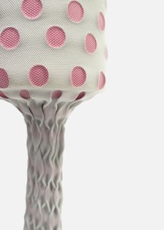 a pink and white polka dot covered object on top of a wooden pole with wire