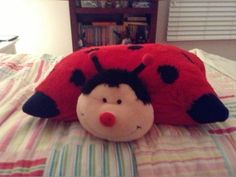 a ladybug stuffed animal laying on top of a bed