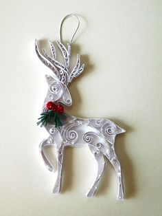 an ornament shaped like a deer with holly on its antlers