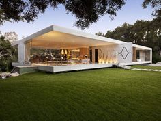 the modern house is surrounded by grass and trees