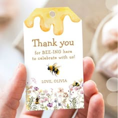 a person holding up a card with a bee on it and the words thank you for being here to celebrate with us