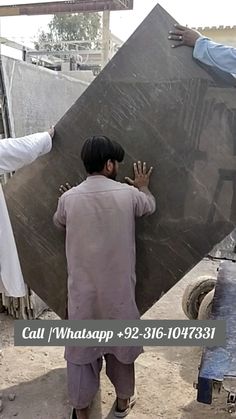 two men carrying a large piece of stone