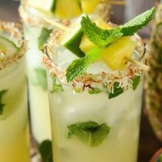 two glasses filled with drinks and garnished with pineapple