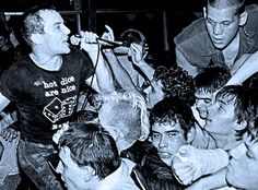 a group of young men standing next to each other in front of a man holding a microphone