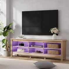 a living room with a large flat screen tv mounted on the wall and purple shelves