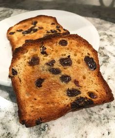 two slices of bread with raisins are on a plate