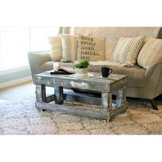 a coffee table sitting on top of a rug in front of a couch with pillows