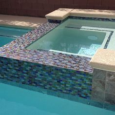 an empty swimming pool with mosaic tiles on the sides