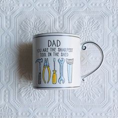 a white coffee mug with tools on it and the words dad you are the sharpest tool in the shed