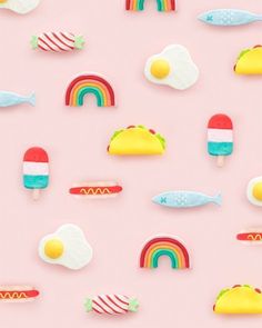 an assortment of food items on a pink background with rainbows, eggs, and fish