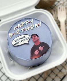 a birthday cake with the image of a man on it is in a plastic container