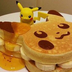 a plate topped with pancakes covered in toppings next to a pokemon pikachu figurine