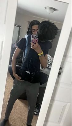 a man taking a selfie in the mirror with his cell phone while wearing leggings