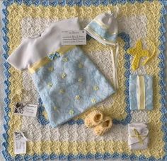 a crocheted blanket with baby items on it