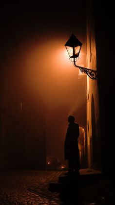 a person standing under a street light in the dark