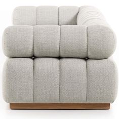 a grey couch with wooden legs on a white background