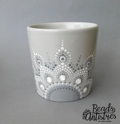 a white cup with silver dots on it