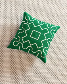 a green and white pillow sitting on top of a couch