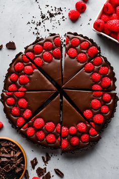 a chocolate cake topped with raspberries on top of a table