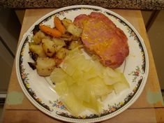 a plate with meat, potatoes and carrots on it sitting on a counter top