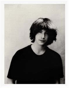 a black and white photo of a person with short hair wearing a t - shirt