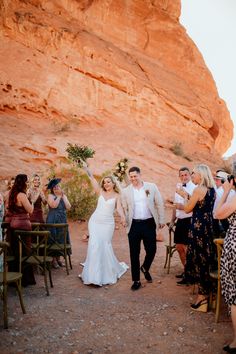 a bride and groom walking down the aisle after their wedding ceremony at red rock canyon