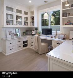 a kitchen with white cabinets and lots of counter space, including a computer on the desk