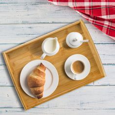 a breakfast tray with coffee and croissants on it, next to a red checkered napkin