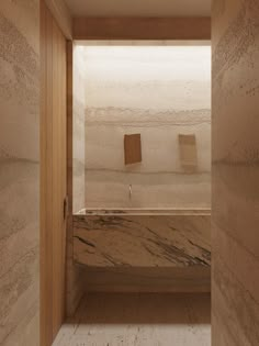 an empty bathroom with marble walls and floor