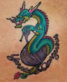 a blue dragon tattoo on the back of a woman's shoulder, with writing underneath it