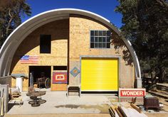 a yellow garage door sits in the middle of a building with an american flag on it