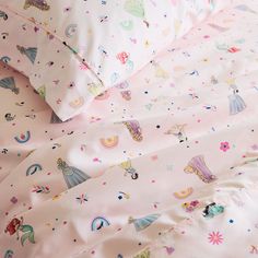 a pink bed with unicorns and stars on it is next to a pillow case