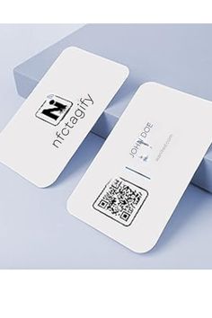 two white business cards sitting on top of each other