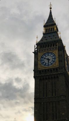 the big ben clock tower towering over the city of london, england on a cloudy day