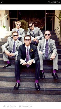 a group of men in suits and ties sitting on steps with one man wearing sunglasses