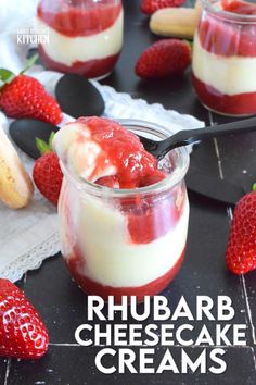 two desserts with strawberries and cream in them on a black surface, one has a spoon