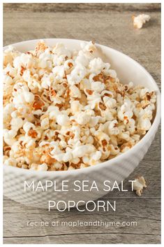 maple sea salt popcorn in a white bowl on a wooden table with text overlay that reads maple sea salt popcorn