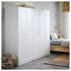 a bedroom with a bed and white cupboards next to a rug on the floor